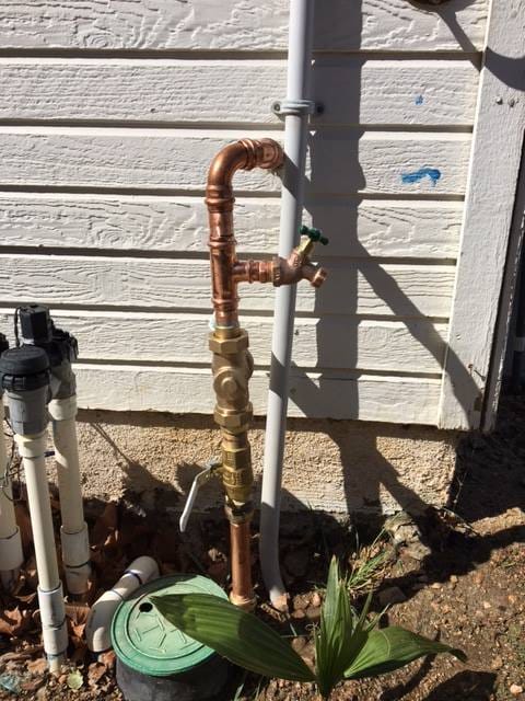 Outdoor spigot with water pressure regulator installation.